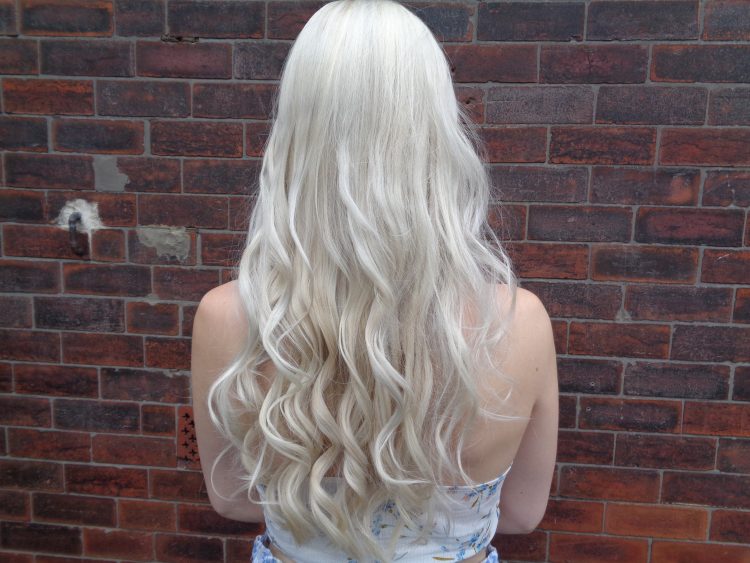 Antonia (Style By Flossie) with her back to the camera to show her white blonde hair in loose curls.